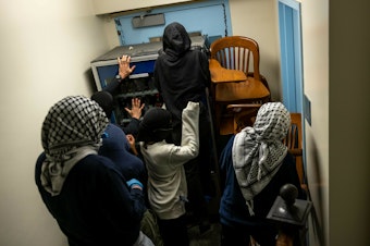 caption: Demonstrators supporting Palestinians in Gaza barricade themselves inside Hamilton Hall, where the office of the dean is located, on April 30 in New York City.