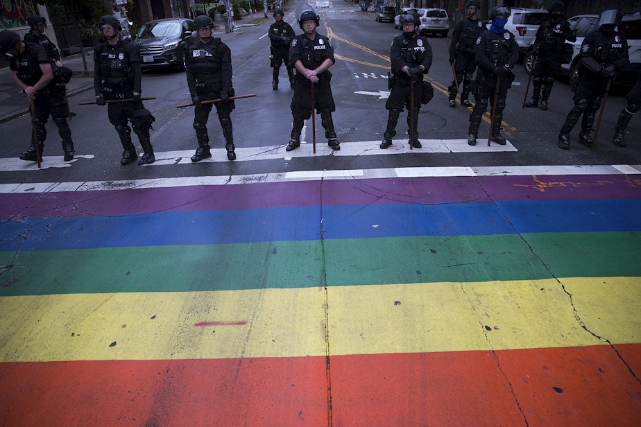 caption: Seattle Police Department officers form a line at the intersection of Broadway and East Pine Street after the Capitol Hill Organized Protest zone was cleared early Wednesday morning, July 1, 2020, in Seattle. 