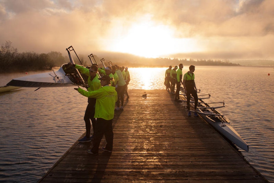 caption: The University of Washington men's rowing team prepares to launch their shells during an early morning practice.