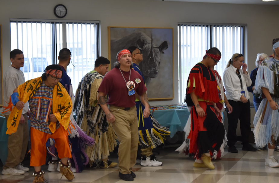 caption: James Rousseau (center in maroon shirt) dances at a powwow in the minimum security unit at Airway Heights Corrections Center last month.