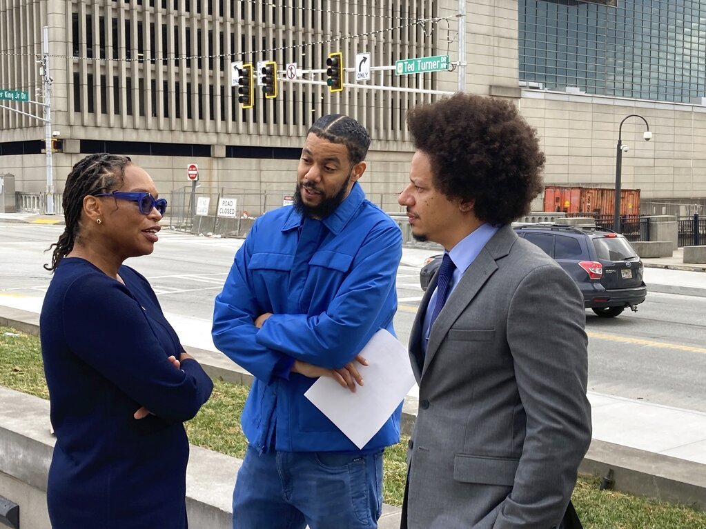 caption: Comedians Clayton English, center, and Eric Andre, right, speak with their attorney, Allegra Lawrence-Hardy, on Tuesday outside the federal courthouse in Atlanta.