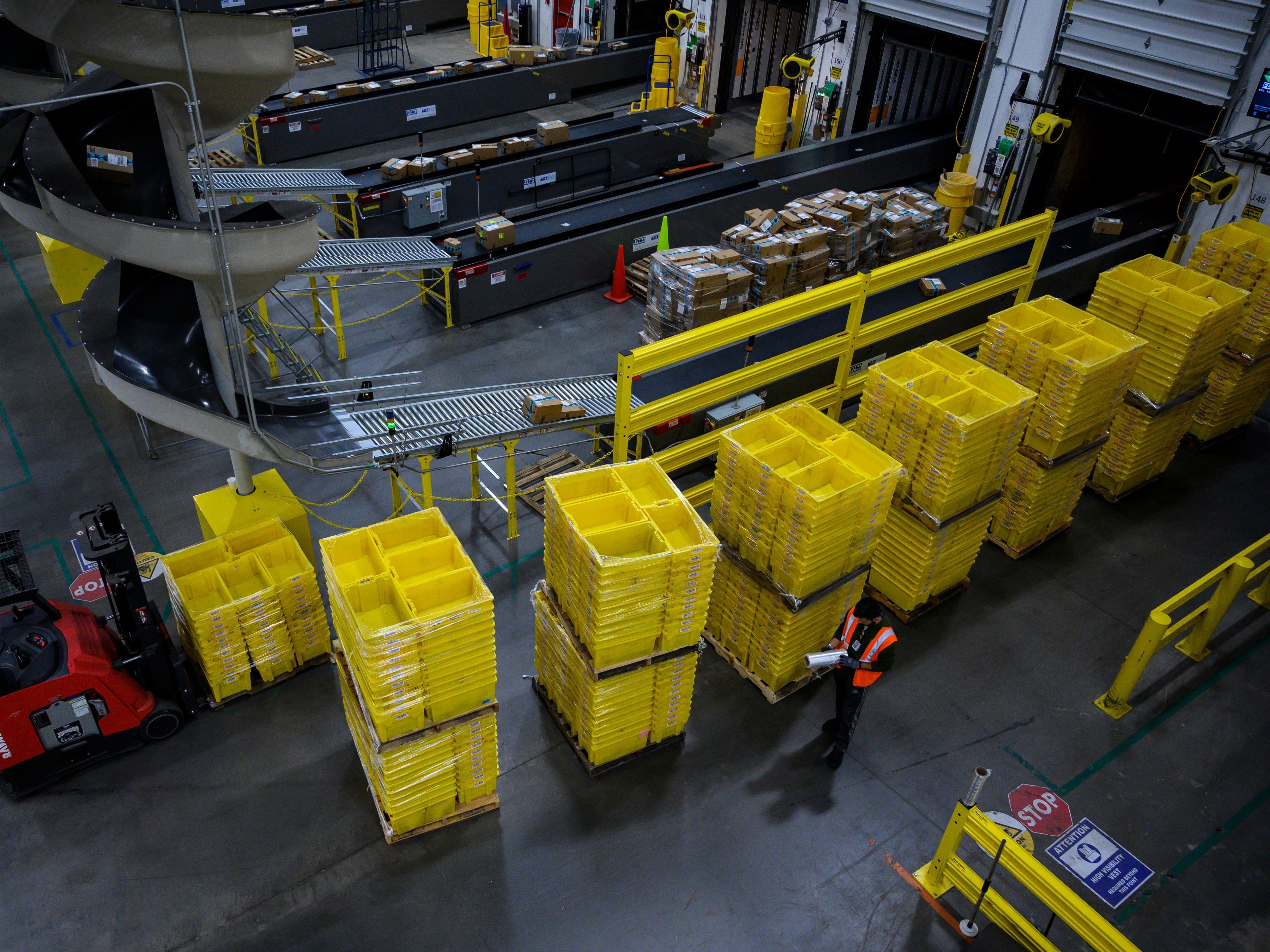 caption: A man works at an Amazon fulfillment center in Staten Island, New York. The retail giant faces a major labor battle with a unionization vote planned at a similar warehouse in Alabama.