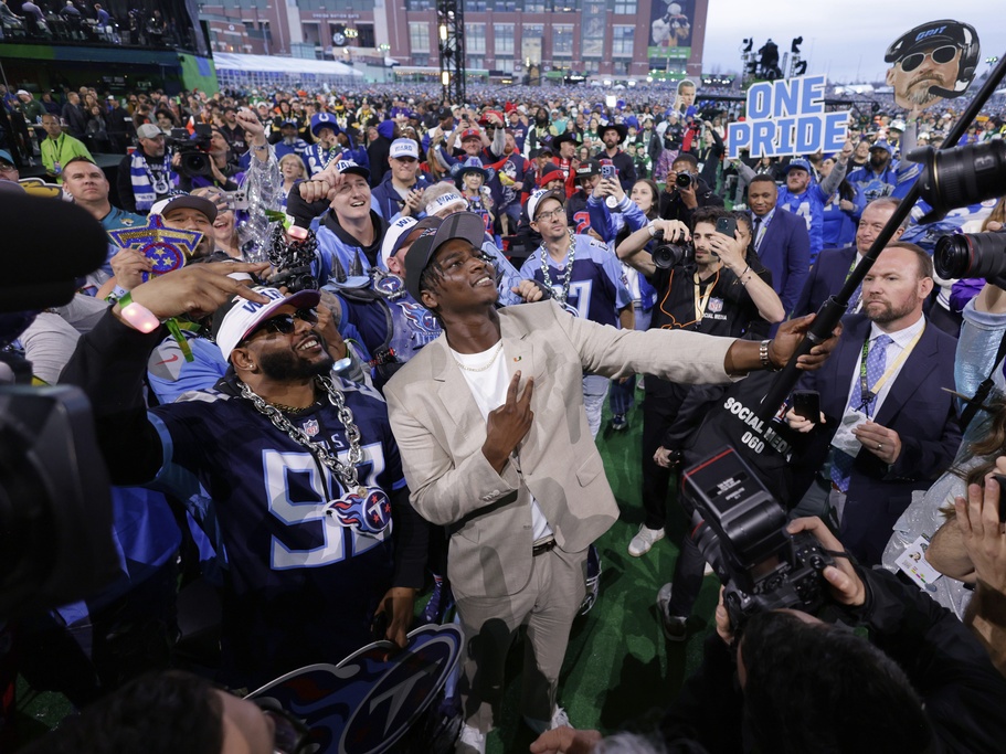 caption: Miami quarterback Cam Ward takes a selfie with fans Thursday after being chosen by the Tennessee Titans with the first overall pick during the first round of the NFL football draft in Green Bay, Wis.