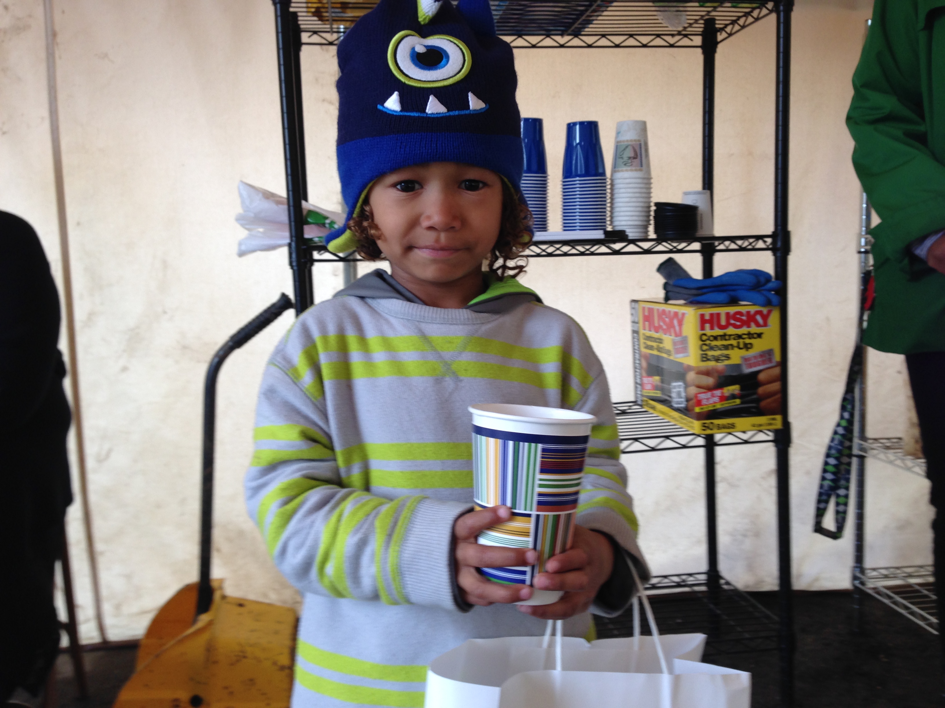 caption: Five-year-old Tiui gets a snack from the makeshift pantry in Othello Village, the newest honeless encampment in southeast Seattle