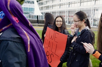 caption: On the one month anniversary of the Parkland shooting, students at Raisbeck Aviation High School in Tukwila held a walk out. A student's sign quoted the words of Parkland student Emma Gonzalez who spoke out against current gun policies.