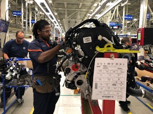 caption: Tremaine Smalls attaches parts to an engine at Volvo's plant in Ridgeville, S.C. The automaker has shifted its exports to Europe as the result of the U.S. trade war with China.