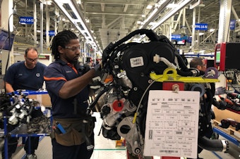 caption: Tremaine Smalls attaches parts to an engine at Volvo's plant in Ridgeville, S.C. The automaker has shifted its exports to Europe as the result of the U.S. trade war with China.