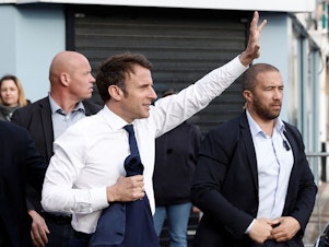 caption: France's President and French liberal party La Republique en Marche (LREM) candidate to his succession Emmanuel Macron waves to supporters during a one-day campaign visit in Hauts-de-France region, in Carvin, northern France, on April 11, 2022.