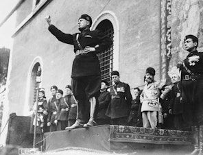 caption: Italian fascist dictator Benito Mussolini (1883 - 1945) giving a speech.   (Fox Photos/Getty Images)