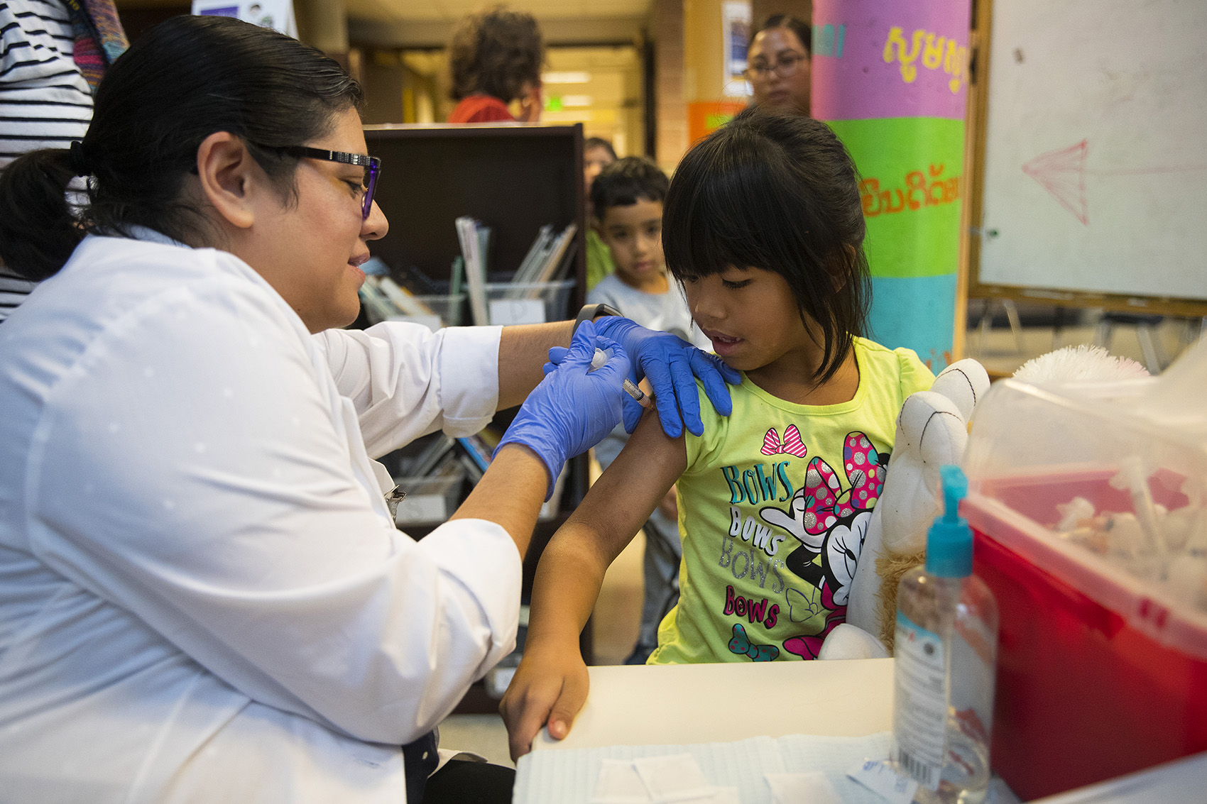 caption: Erika Sandoval, a nurse with the Seattle Visiting Nurse Association, gives kindergartener Aaliyah Tuilagi-Su a flu shot on Tuesday, October 22, 2019, at Concord International Elementary School in Seattle.