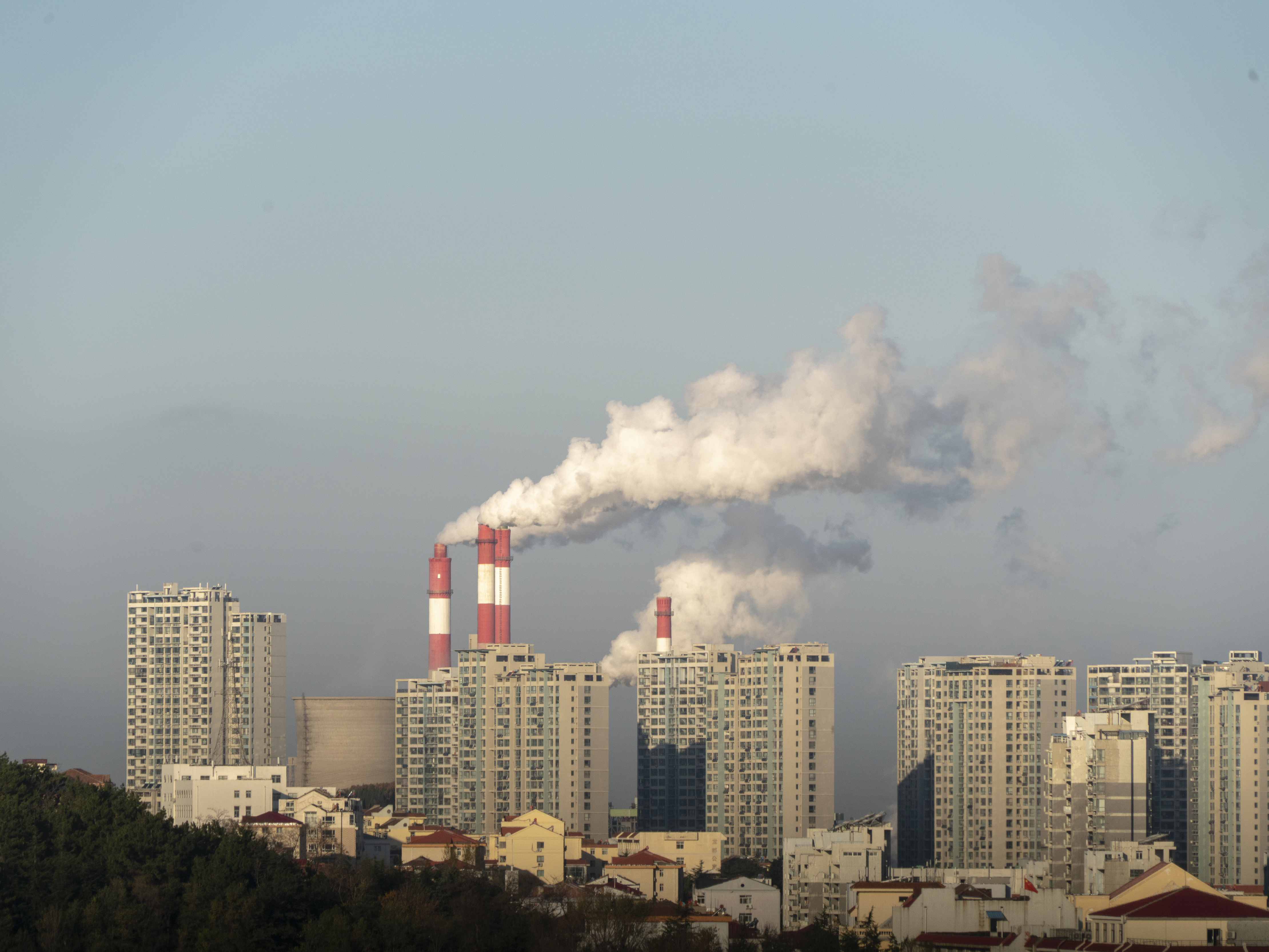 caption: Smokestacks belch in Weihai, in China's Shandong province, in 2019. China is set to surpass pre-pandemic levels of carbon dioxide emissions this year.