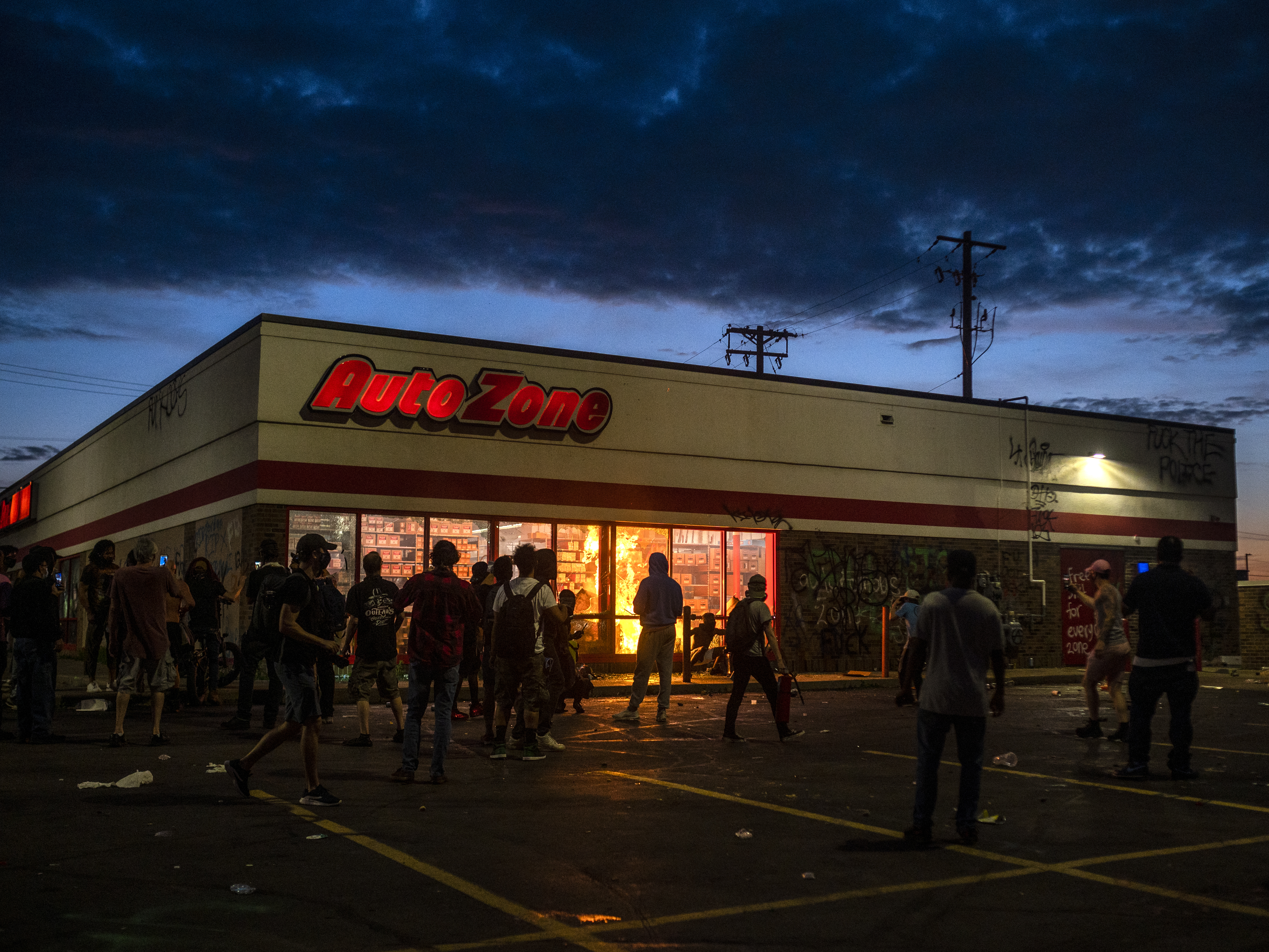 caption: An Auto Zone store was among the Minneapolis buildings looted and damaged on May 27 during the protests against police violence. Police investigators reportedly have a suspect in the vandalism that preceded the burning of the store.