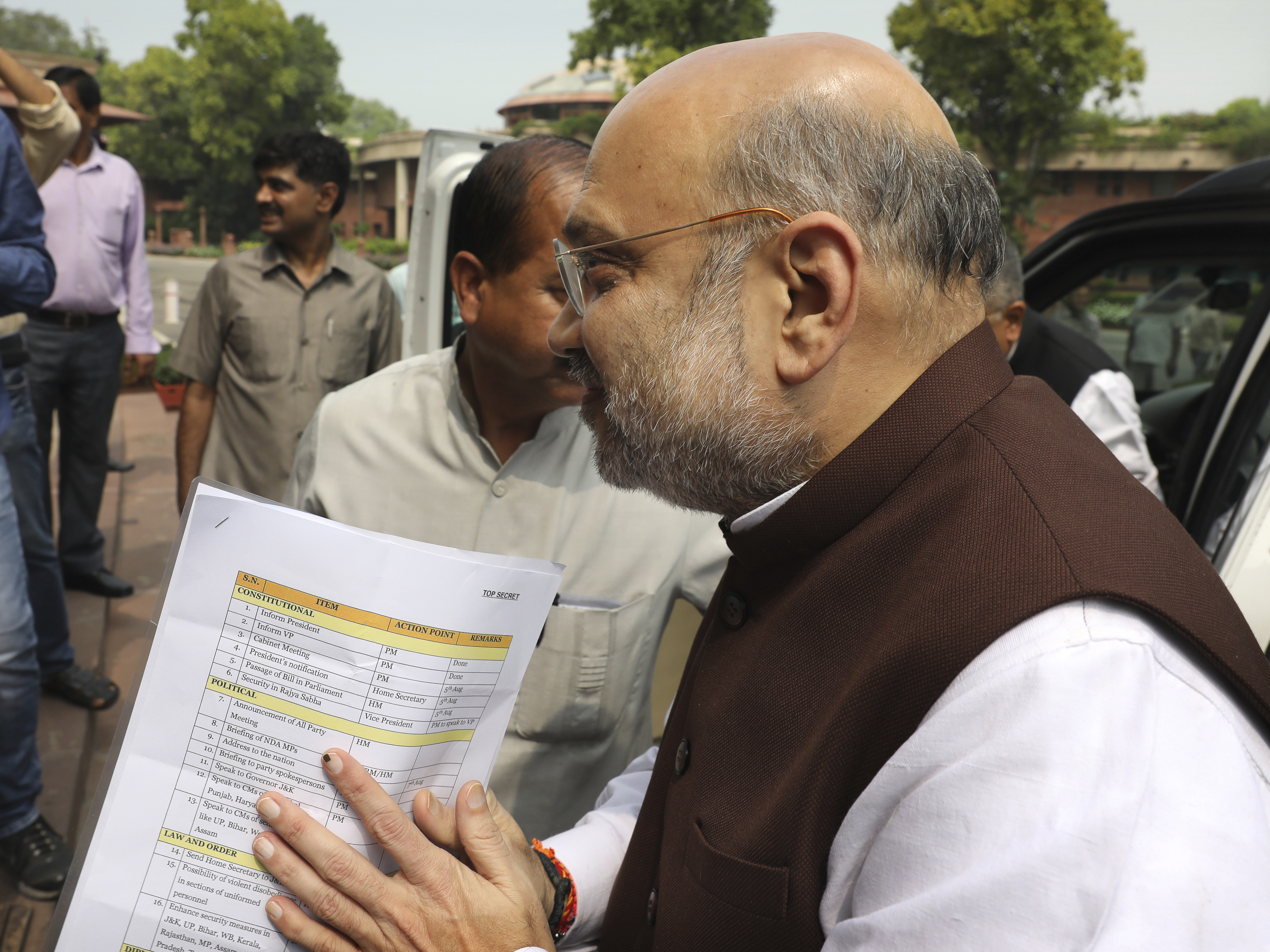 caption: Indian Home Minister Amit Shah arrives at the Parliament on Monday carrying a copy of a confidential document that lists the procedure for revoking Kashmir's special status in New Delhi.