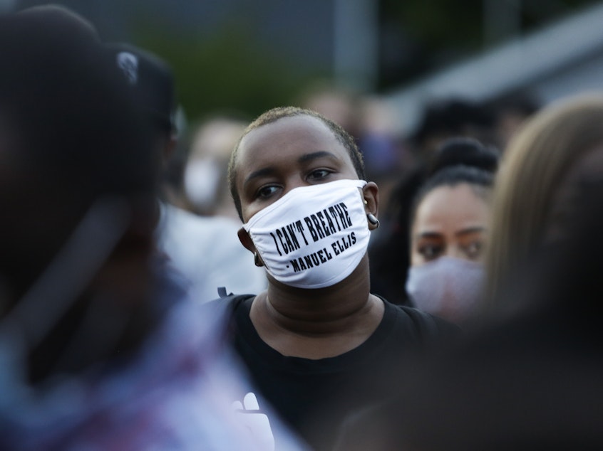 caption: A man at a vigil this week wears a mask with the words "I can't breathe" above the name of Manuel Ellis, a 33-year-old black man whose death in Tacoma, Wash., police custody was recently ruled a homicide.