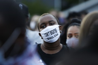 caption: A man at a vigil this week wears a mask with the words "I can't breathe" above the name of Manuel Ellis, a 33-year-old black man whose death in Tacoma, Wash., police custody was recently ruled a homicide.