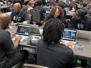 caption: Marvin Jones (left) and Rose Washington-Jones (center), from Tulsa, Okla., took part in the AI red-teaming challenge at Def Con earlier this month with Black Tech Street.