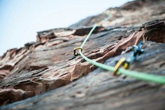 caption: Anchors in the side of a rock face for rock climbers. 