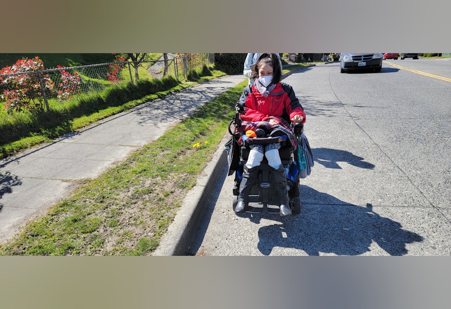 caption: Tanisha Sepulveda says she has to drive her heavy wheelchair on the shoulder of the road to get to the nearest bus stop in her Highland Park neighborhood. 