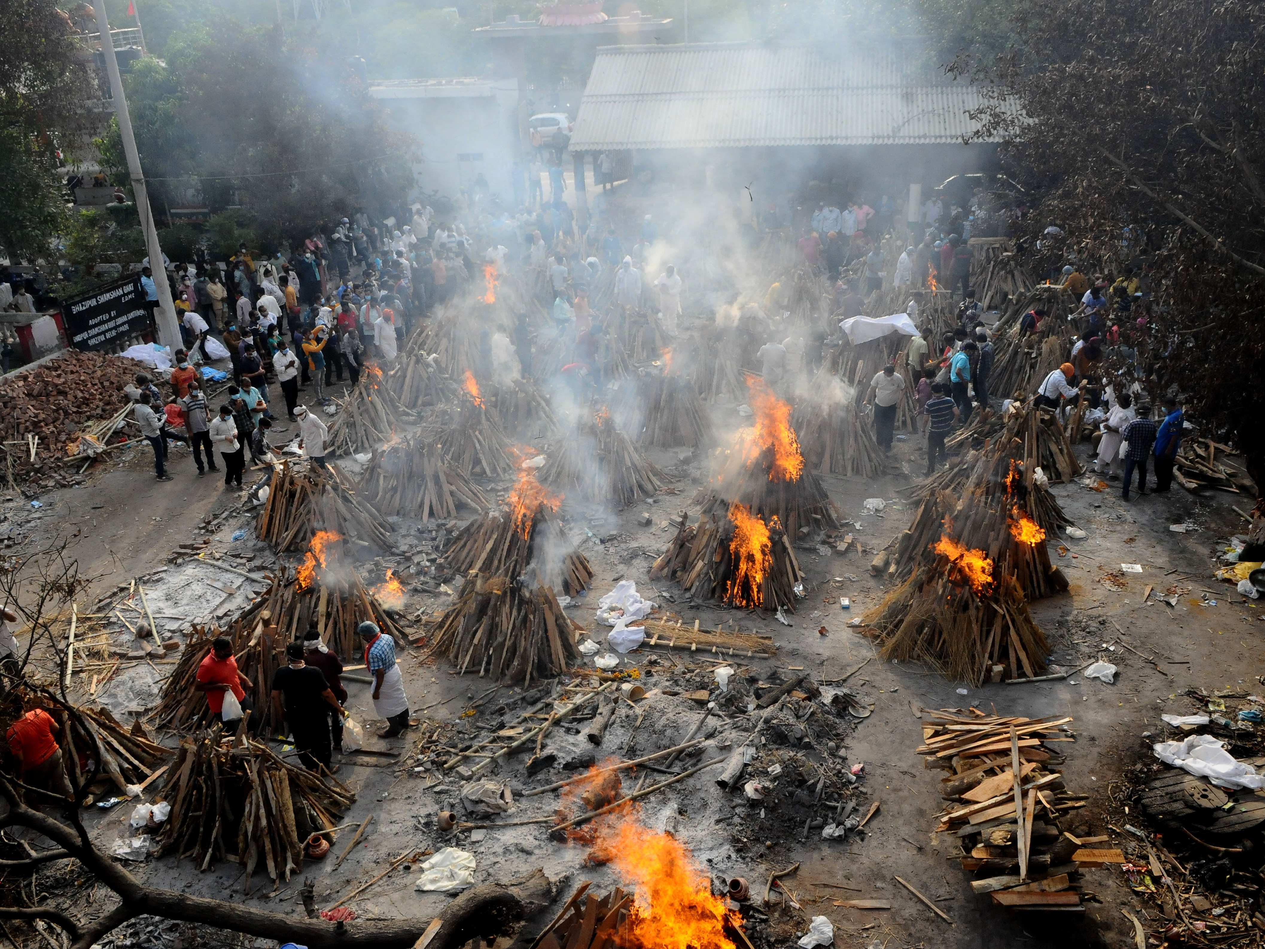 caption: A mass cremation of people who died from from COVID-19 in New Delhi, India on April 28, 2021. A new WHO report on "excess deaths" compares their calculations with official numbers and finds millions more people died that the government-provided global total, with India a key example. India disputes the WHO finding and stands by its lower numbers.