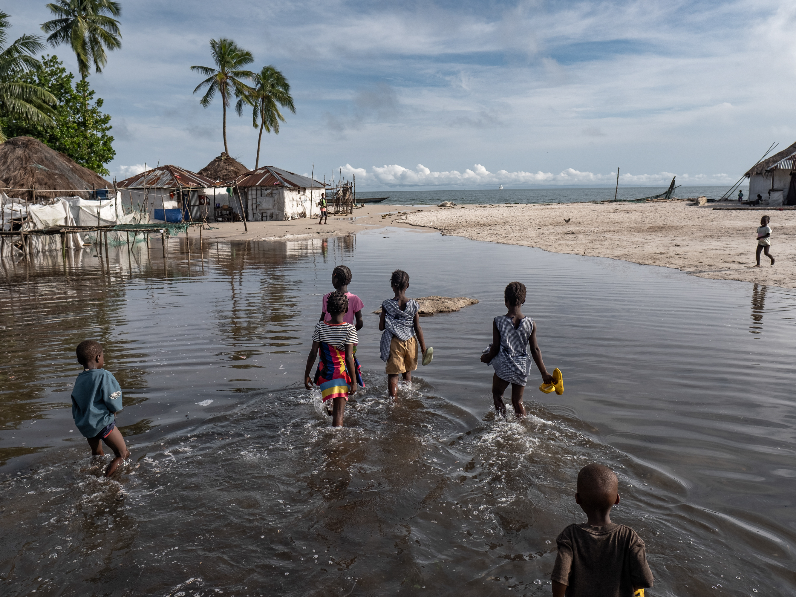 caption: Children wade through floodwater on Nyangai Island, Sierra Leone. Most of the island has already been lost to the sea, and what remains is routinely flooded at high tide.