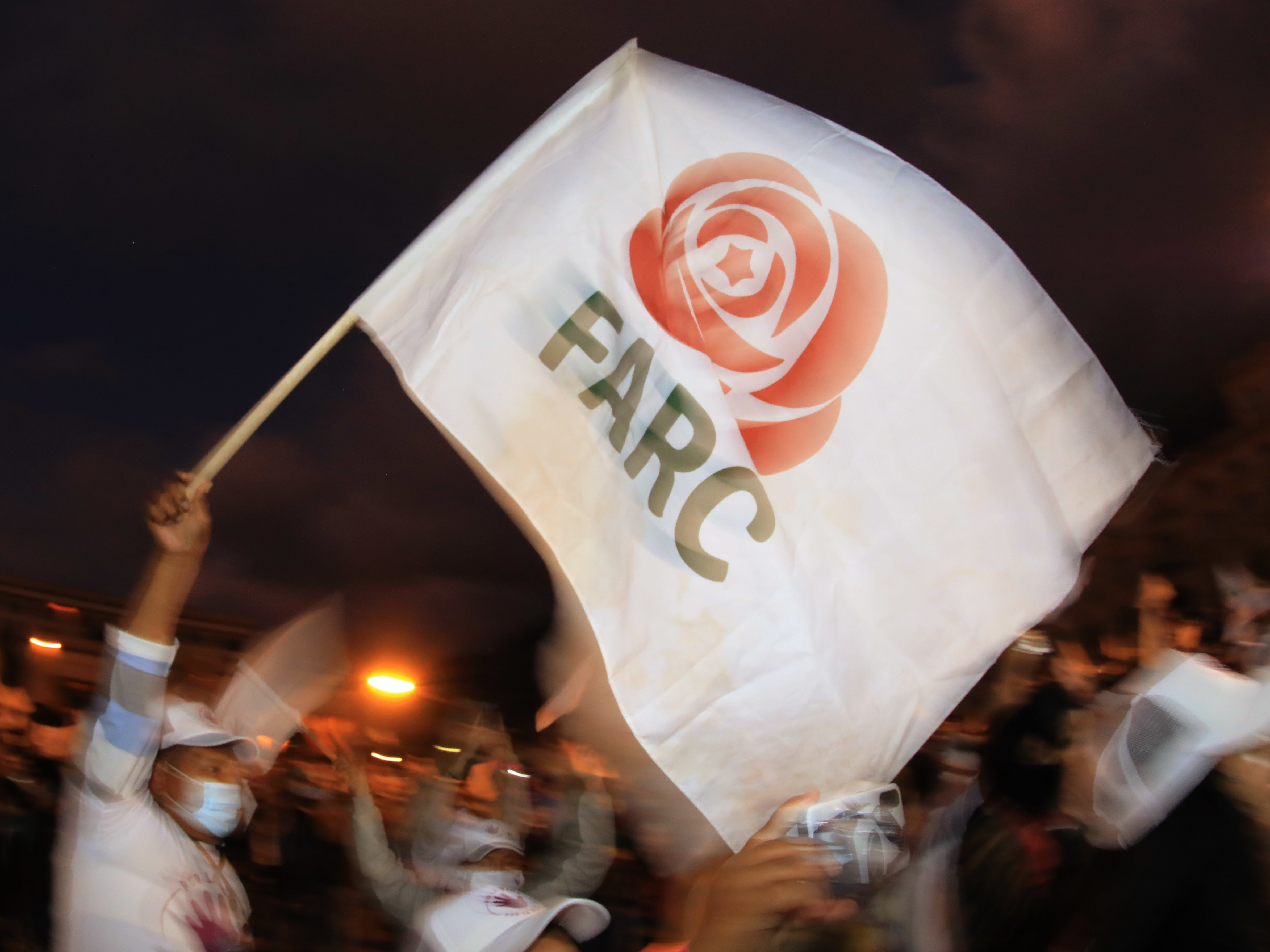 caption: A former FARC guerrilla member waves a FARC political party flag during a demonstration in Bogota on Nov. 2. A federal court overturned an asylum decision Wednesday, holding that FARC death threats counted as persecution.×