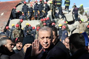 caption: Turkish President Recep Tayyip Erdogan tours the site of destroyed buildings during his visit to the city of Kahramanmaras, in southeast Turkey, on Wednesday, two days after the severe earthquake that hit the region.