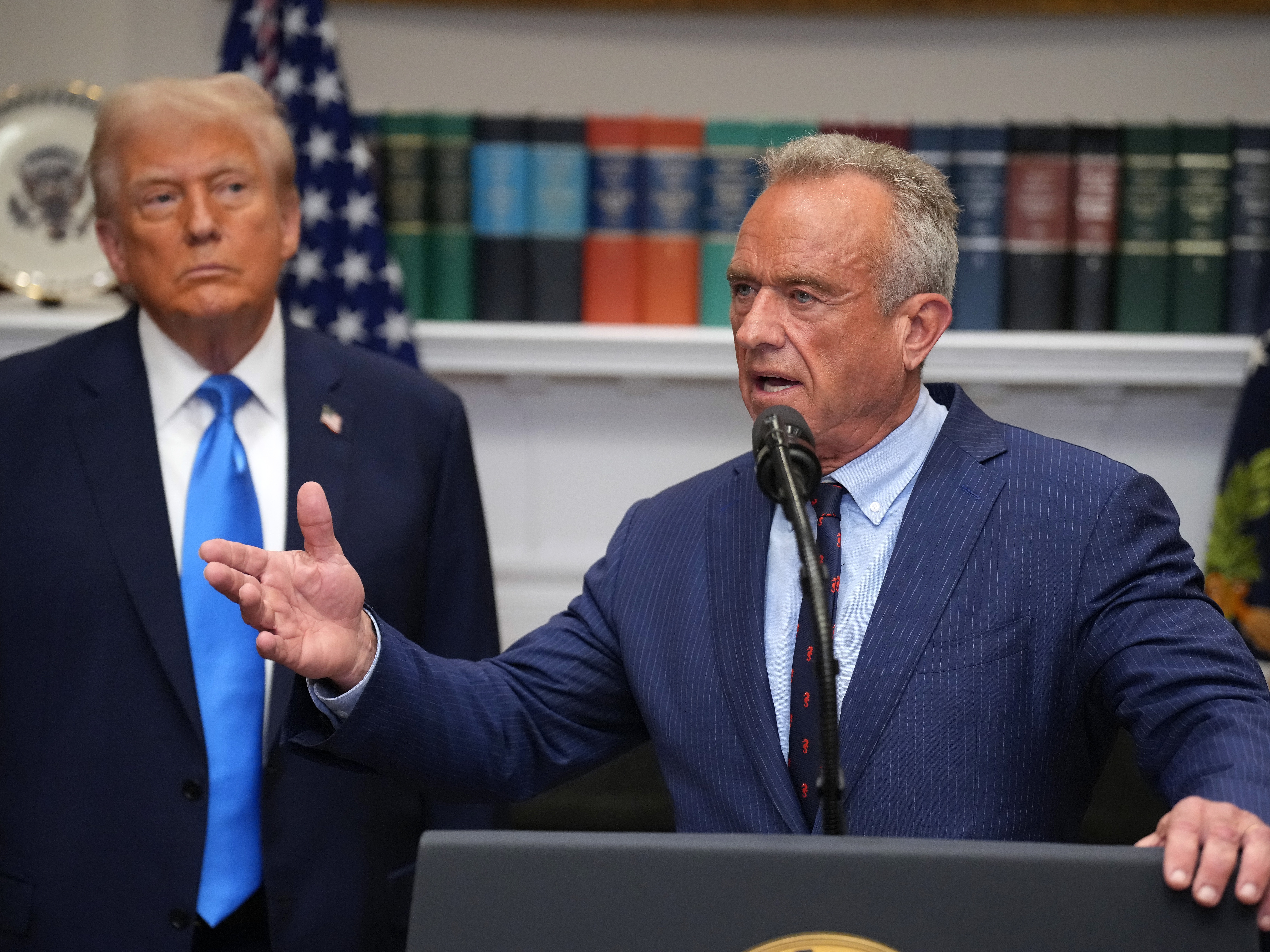 caption: President Trump (left) looks on as Health and Human Services Secretary Robert F. Kennedy Jr. answers questions after delivering an announcement on "significant medical and scientific findings for America's children" in the Roosevelt Room of the White House on Sept. 22 in Washington, D.C.