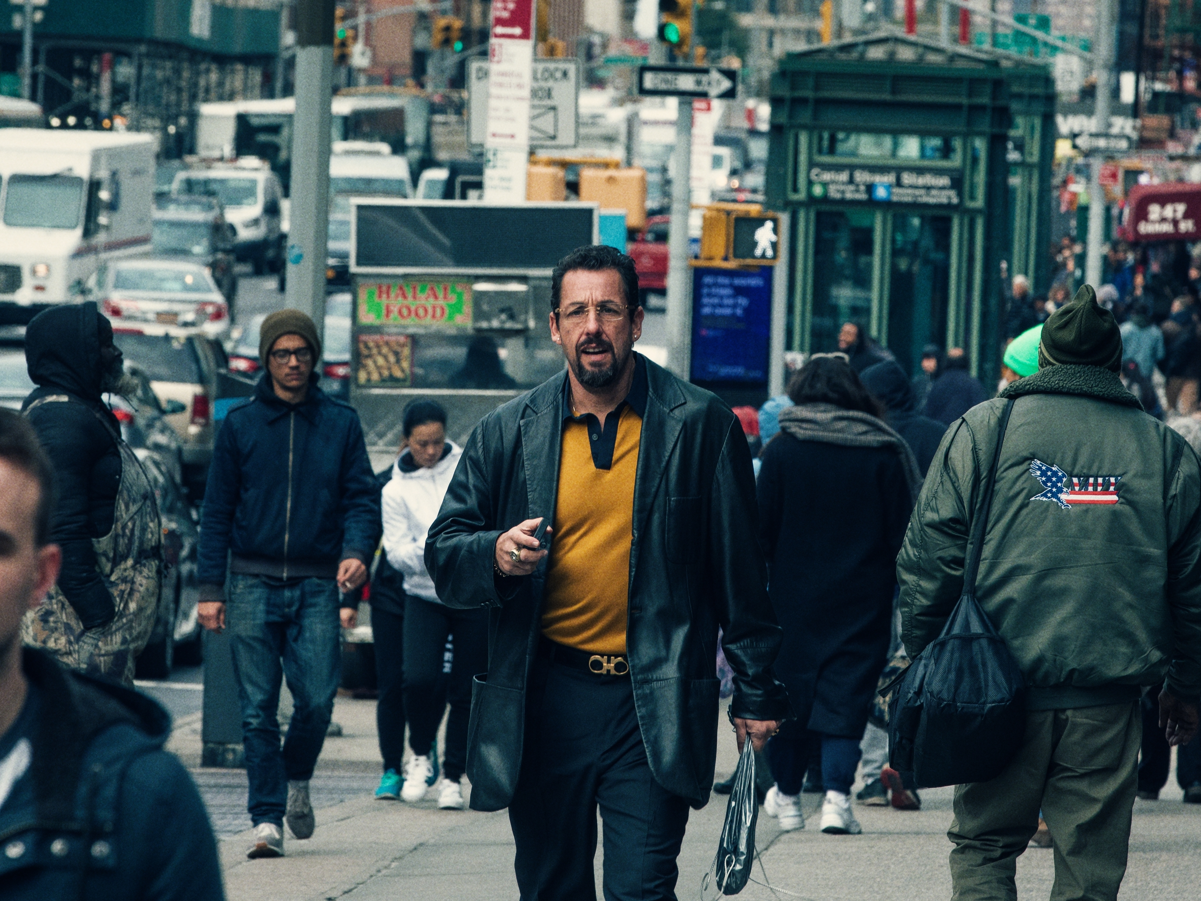 caption: Adam Sandler plays jeweler Howard Ratner in the film <em>Uncut Gems</em>. The score is as shiny and cosmic as Ratner's life is messy and frantic.