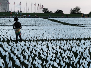 caption: <em></em>Flags at the Washington Monument commemorate Americans who died from  COVID-19. In 2021, life expectancy in the U.S. fell for the second year in a row.
