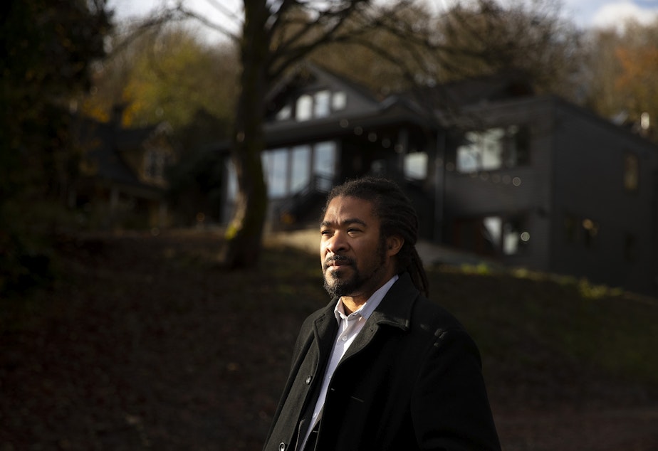 caption: Rico Quirindongo stands for a portrait in front of a home that he used to live in, on Thursday, Dec. 1, 2022, along 27th Avenue South in Seattle. 