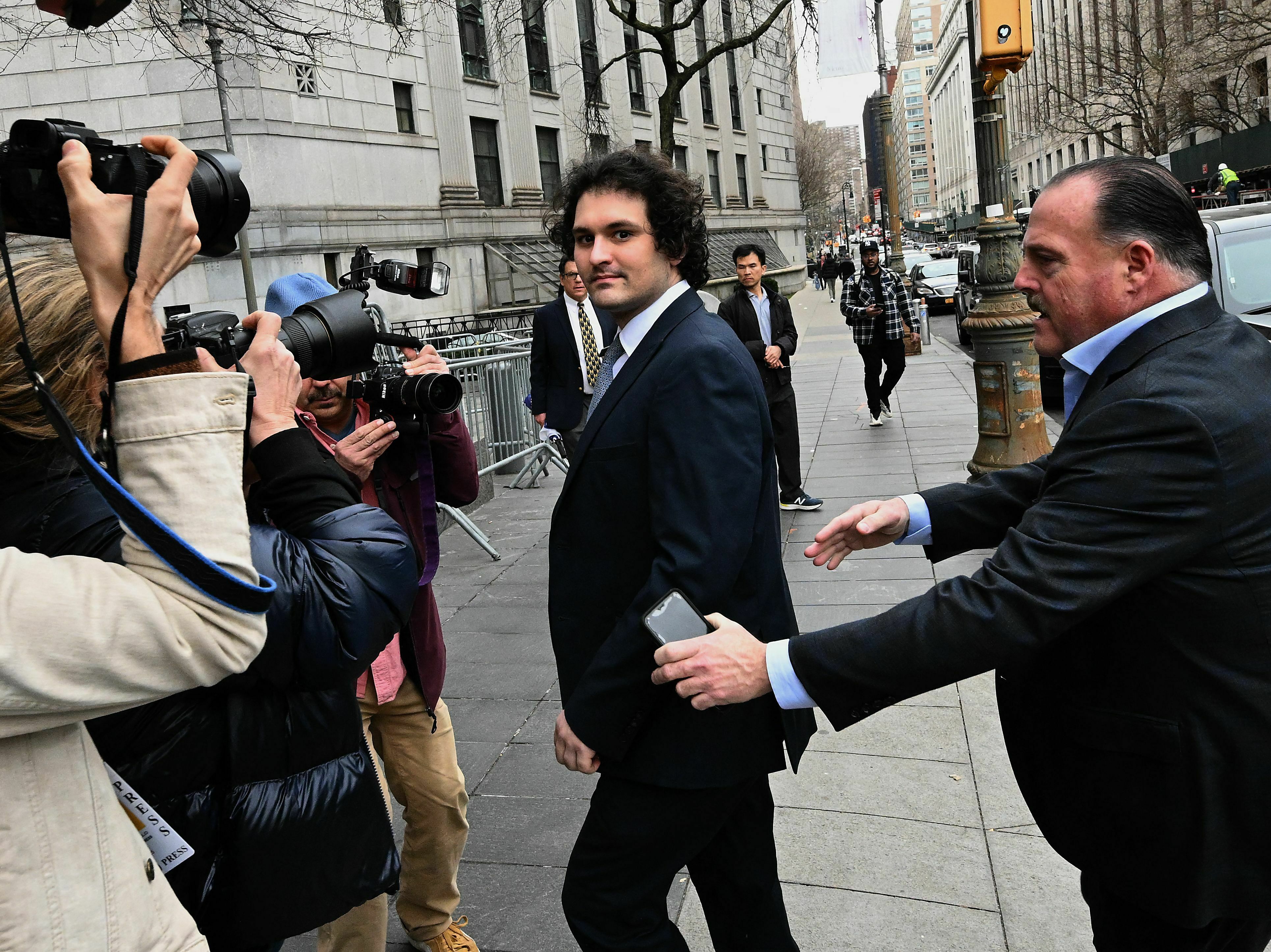 caption: FTX founder Sam Bankman-Fried arrives at the U.S. Federal Court in New York for a hearing on Feb. 16, 2023. As he awaits trial, the disgraced former CEO is defending himself in the court of public opinion.