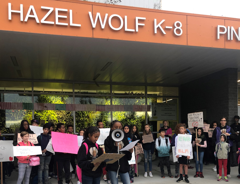 caption: Hazel Wolf K-8 STEM School seventh-graders Melat Zigta and Zariyah Quiroz speak at a protest at the school on Friday, Oct. 25, 2019.