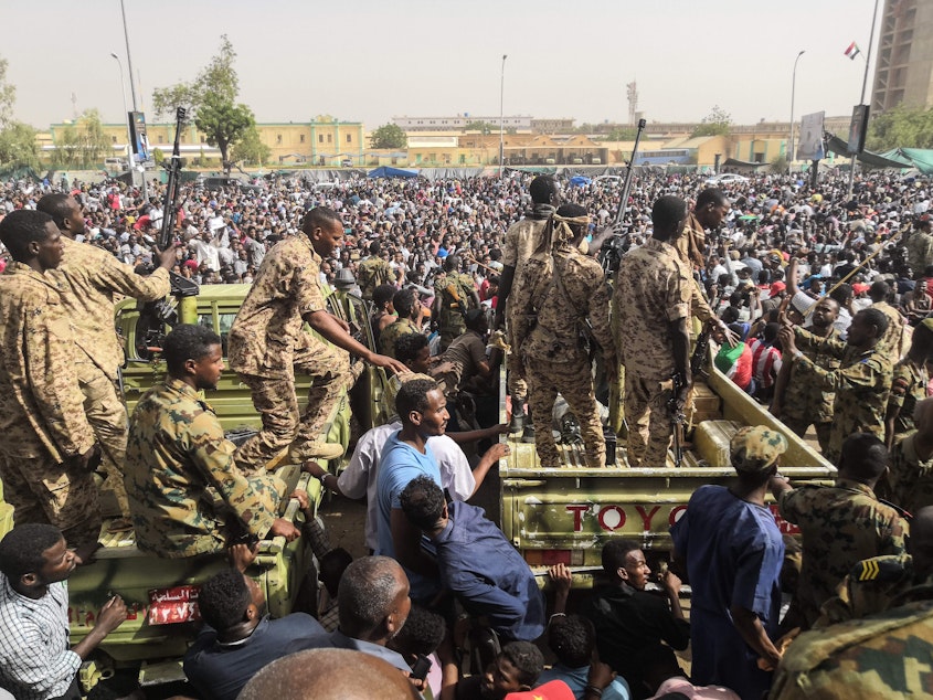 caption: Sudanese soldiers stand guard on armored vehicles as demonstrators protest against President Omar al-Bashir's regime near the army headquarters in the Sudanese capital Khartoum Thursday.
