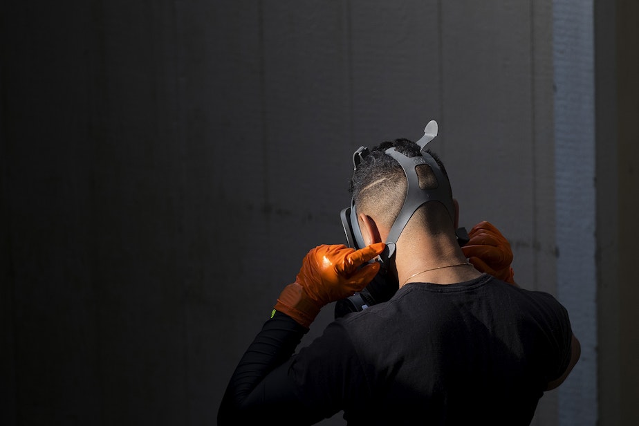caption: A member of a Servpro cleaning crew removes a protective face mask after exiting the Life Care Center of Kirkland, the long-term care facility at the epicenter of the coronavirus outbreak in Washington state, on Wednesday, March 11, 2020, in Kirkland. 