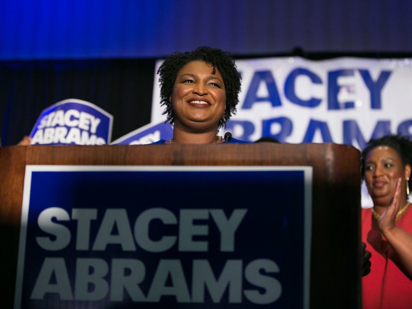 caption: Then-Georgia Democratic gubernatorial candidate Stacey Abrams takes the stage to declare victory in the primary during an election night event in May 2018.