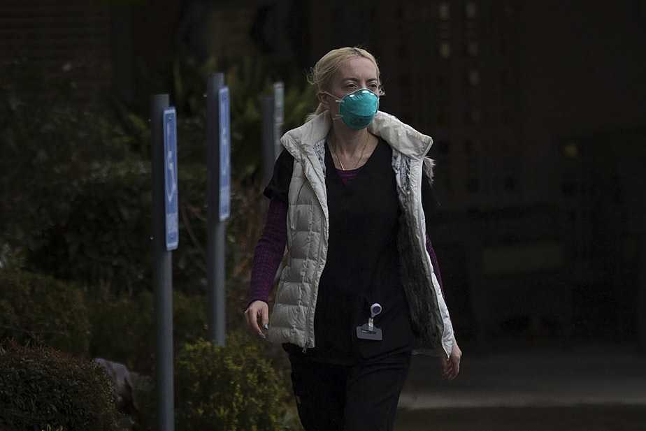 caption: An employee at the Life Care Center of Kirkland leaves the facility wearing a mask on Monday, March 2, 2020, in Kirkland. The long-term care facility is the epicenter of the coronavirus outbreak in Washington state.