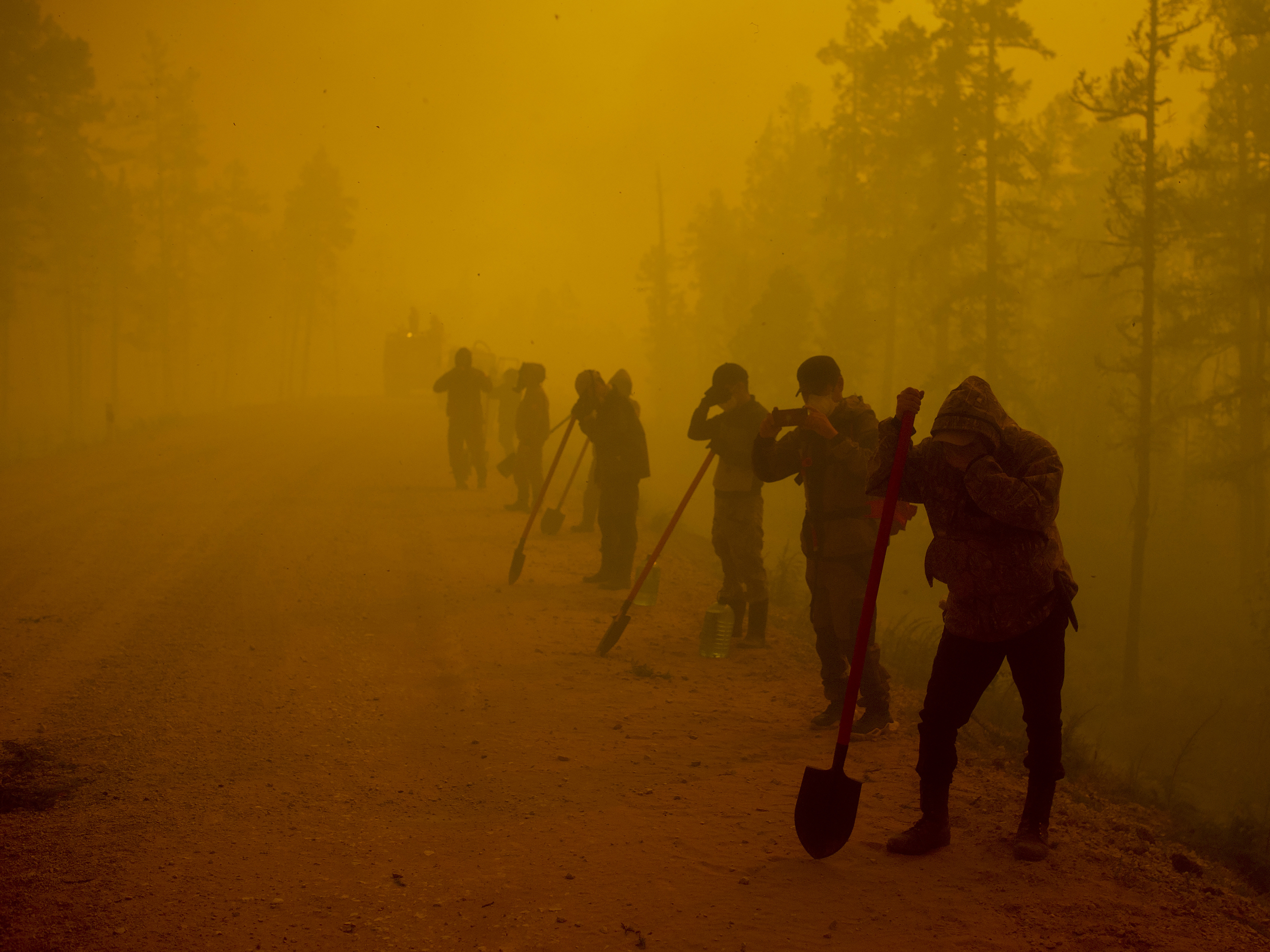 caption: Volunteer firefighters rested west of Yakutsk, Russia in August 2021. Wildfires are getting more common in Siberia, undercutting the ability of the region's vast forests to absorb carbon dioxide from the atmosphere.