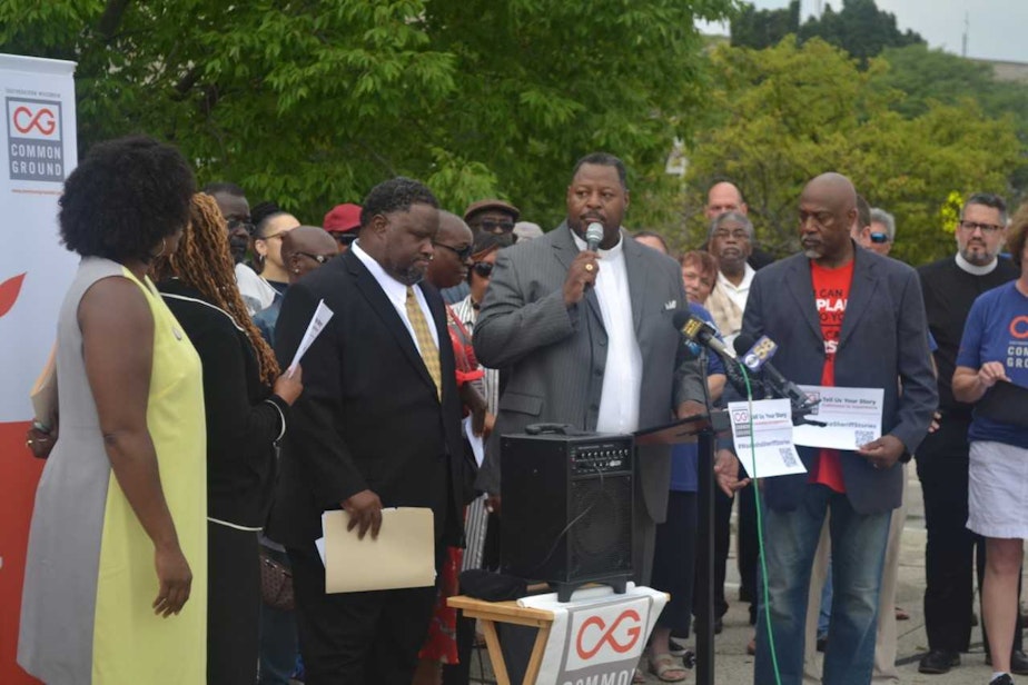 caption: Demetrius Williams of Community Baptist Church in Milwaukee and John K. Patterson (with microphone) of Mt. Olive Baptist Church in Milwaukee speak during an event organized by Common Ground. (Courtesy Common Ground)