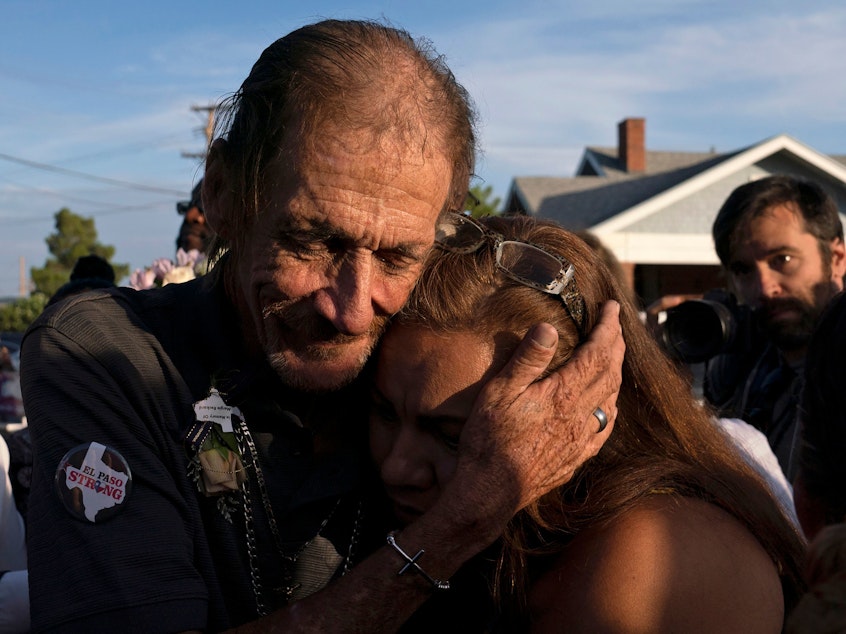 caption: Antonio Basco, husband of El Paso Walmart shooting victim Margie Reckard, hugs an attendee during his wife's visitation service in El Paso, Texas, in August.