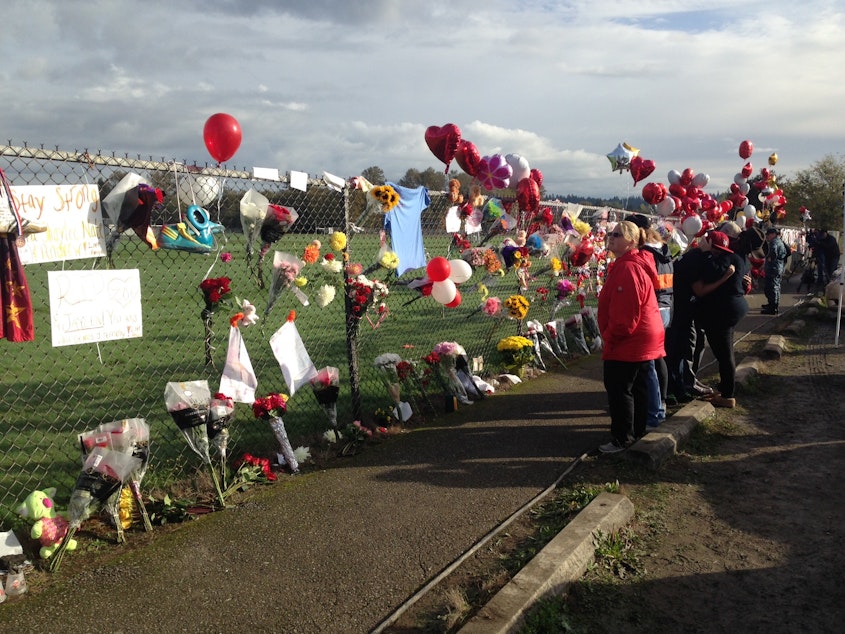 caption: Students and community members visit the memorial that's taken shape at Marysville Pilchuck High School.