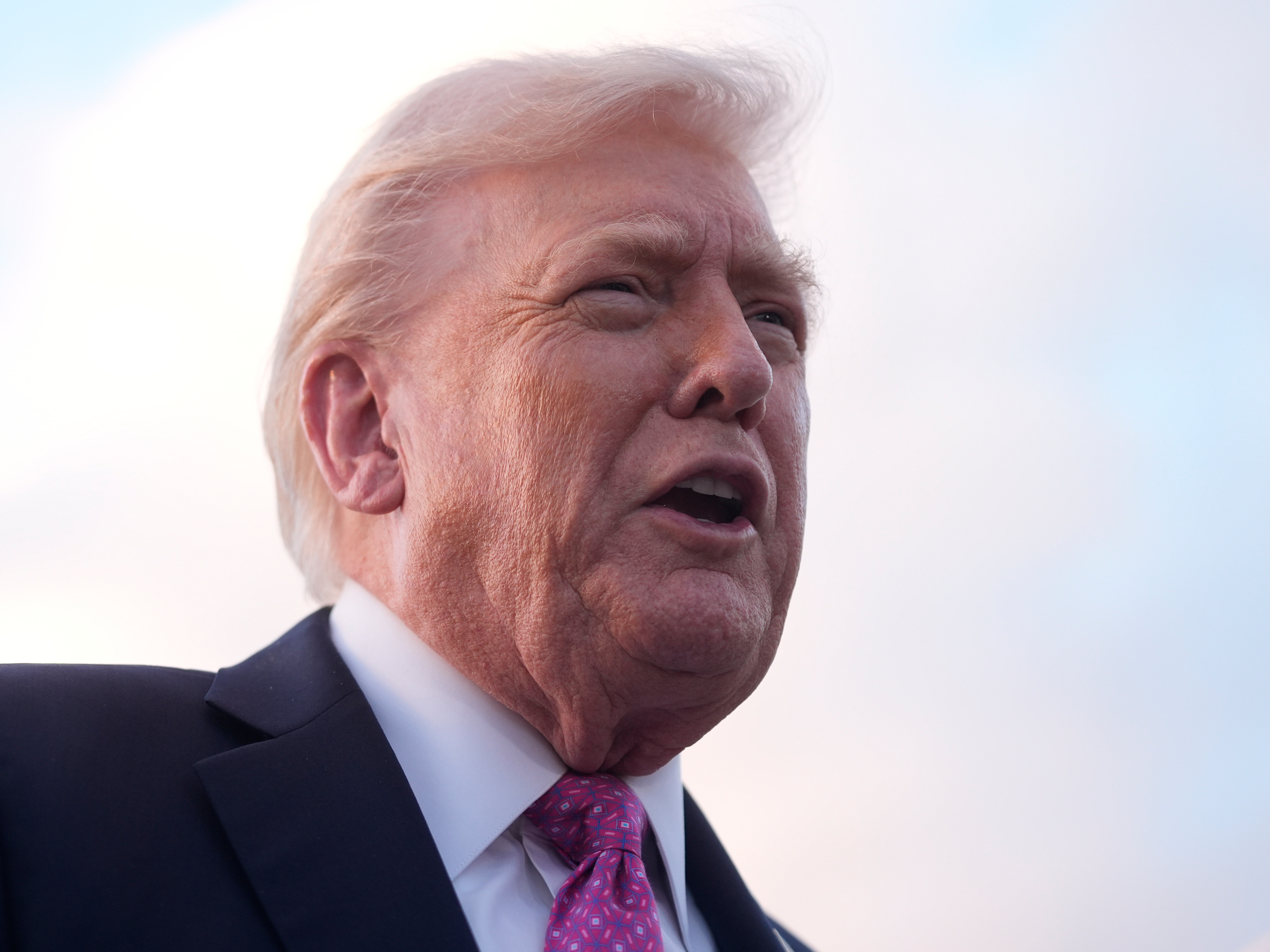 caption: President Trump speaks to reporters after arriving on Air Force One, Friday, at Palm Beach International Airport in West Palm Beach, Fla.