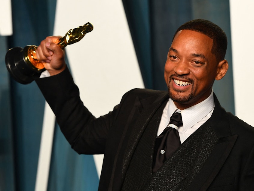 caption: Will Smith holds his award for best actor in a Leading Role for <em>King Richard</em> as he attends the 2022 Vanity Fair Oscar Party.