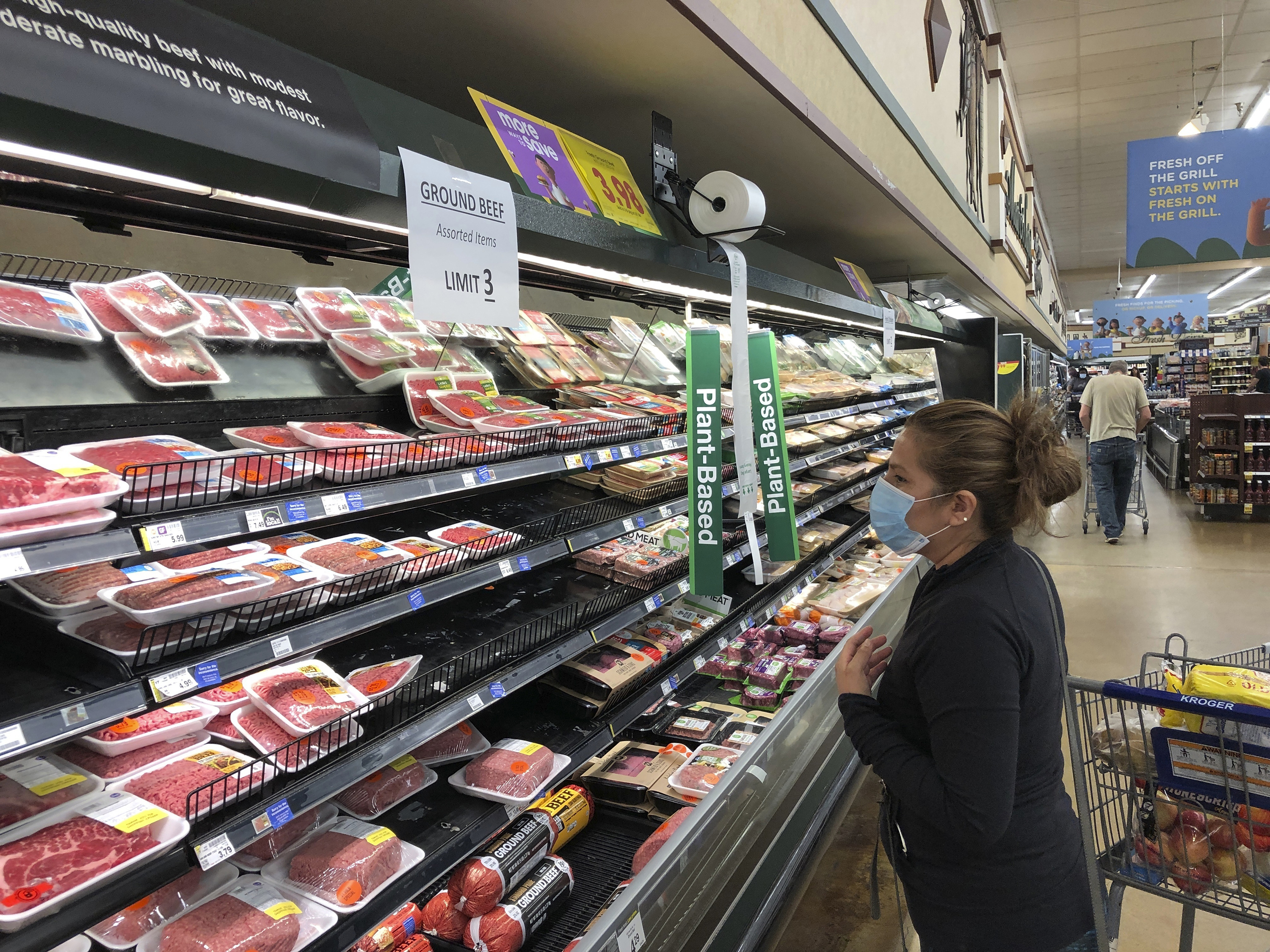 caption: A shopper looks at beef at a Kroger store in Atlanta on May 5, 2020.