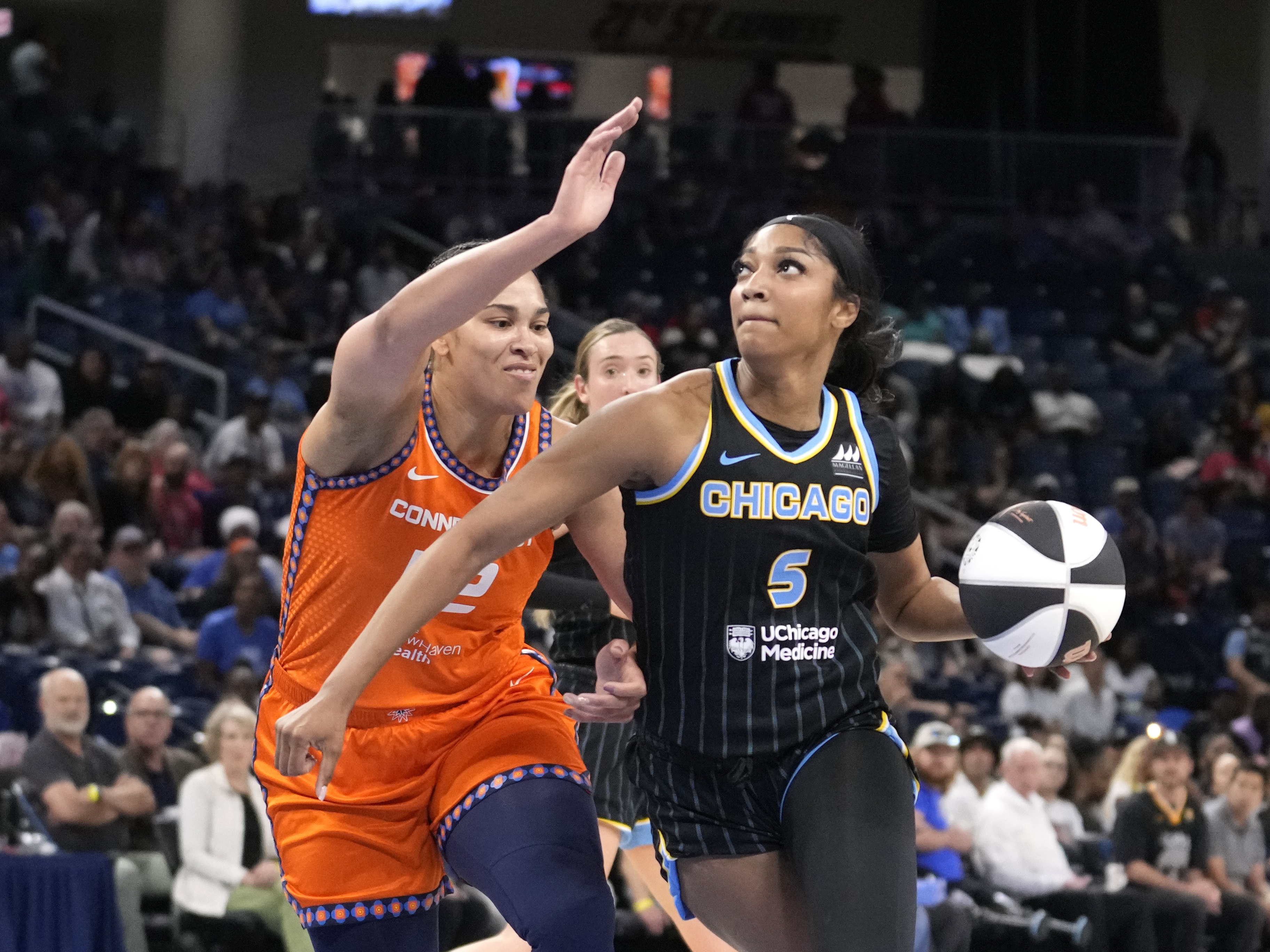 caption: Chicago Sky's Angel Reese (5) eyes the basket as Connecticut Sun's Brionna Jones defends during a WNBA basketball game on June 12, 2024, in Chicago. 