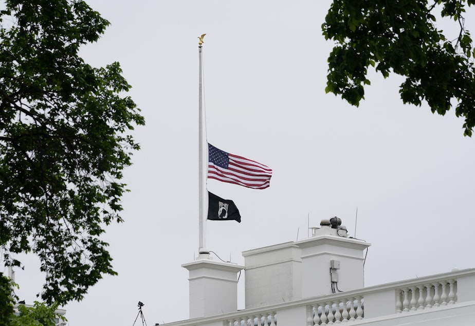 caption: The American flag flies at half-staff at the White House on Thursday as President Biden commemorates 1 million American lives lost due to COVID-19.