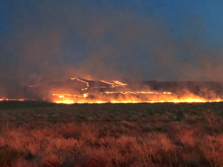 caption: File photo of a brush fire burning in the Rattlesnake Mountain area of Washington's Tri-Cities region in 2019.