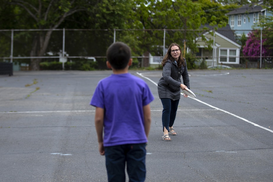 caption: Kadie Bell Sata plays frisbee with her oldest son, in fifth grade, on the Greenlake Elementary playground after school on Monday, June 3, 2024, in Seattle. 