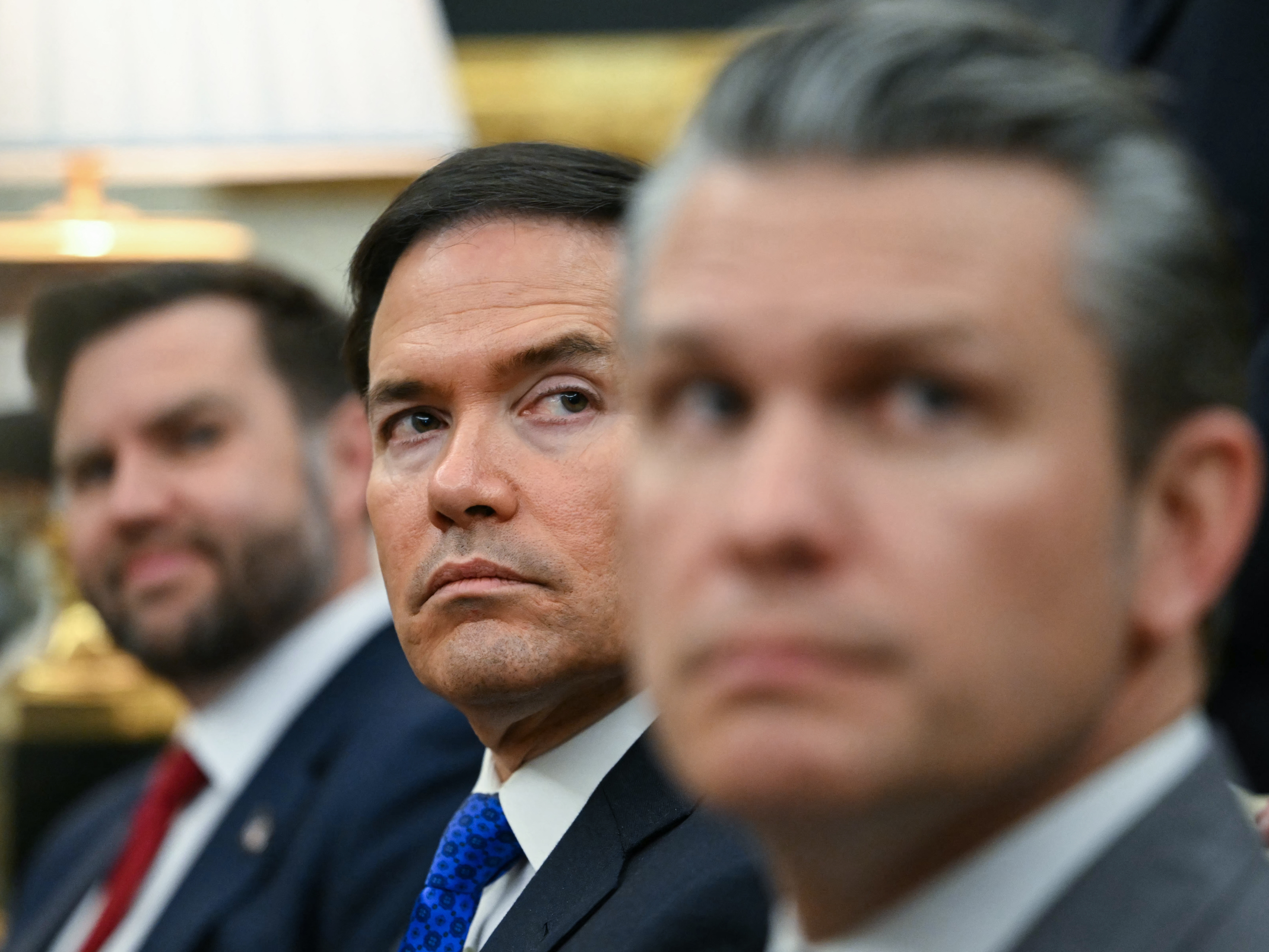 caption: Vice President Vance, Secretary of State Marco Rubio and Defense Secretary Pete Hegseth look on as President Trump meets with German Chancellor Friedrich Merz in the White House on March 3.