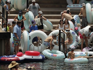 caption: Tubers prepare to float the Comal River in New Braunfels, Texas, on Thursday. Texas Gov. Greg Abbott said Wednesday that the state is facing a "massive outbreak" of the coronavirus and that some new local restrictions may be needed to preserve hospital space for new patients.