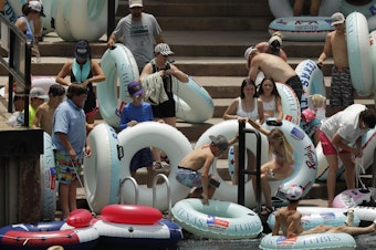 caption: Tubers prepare to float the Comal River in New Braunfels, Texas, on Thursday. Texas Gov. Greg Abbott said Wednesday that the state is facing a "massive outbreak" of the coronavirus and that some new local restrictions may be needed to preserve hospital space for new patients.